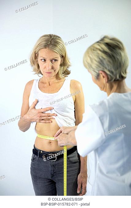 A woman measuring her waist