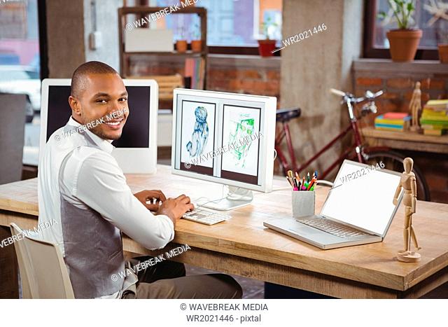 Smiling cartoonist working on computer