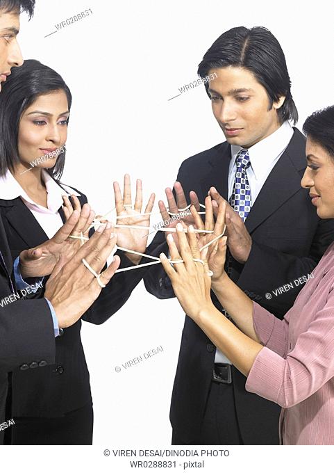 South Asian Indian executive men and women doing the cats cradle with thread MR