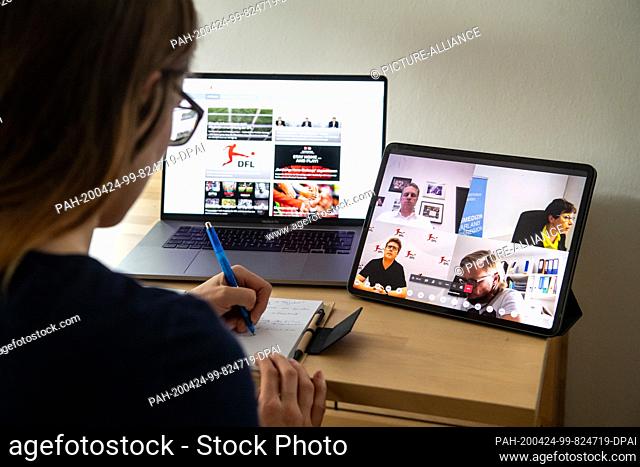 24 April 2020, Bavaria, Munich: ILLUSTRATION - A woman takes notes during an online press conference after a general meeting of the German Football League on...