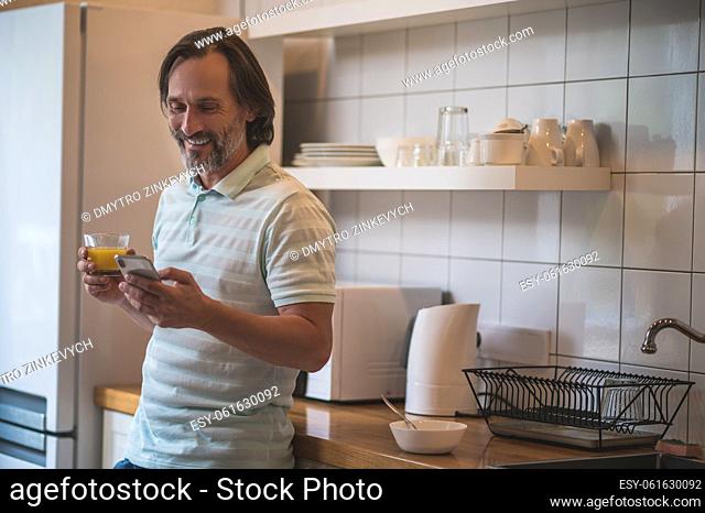 Time to eat. Smiling contented man having breakfast in the kitchen