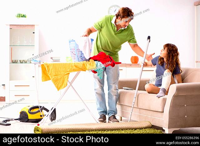 Husband helping leg injured wife in housework
