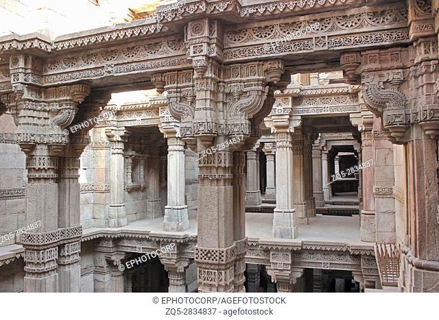 Upper storeys with intricate stone carvings on pillars, pilaster and entablature. Adalaj Stepwell, Ahmedabad, Gujarat, India