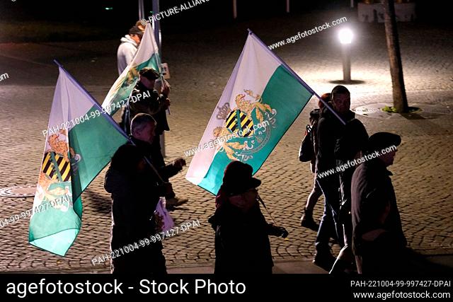 03 October 2022, Thuringia, Erfurt: Participants of a rally walk down a street with flags. The demonstration brought together about 150 sympathizers of the...