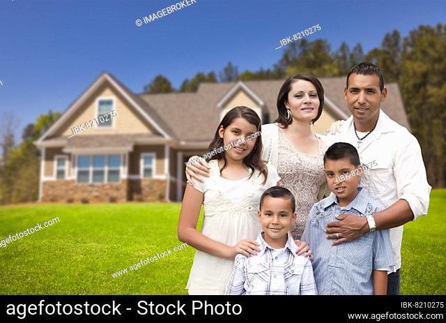Happy young hispanic family in front of their new home