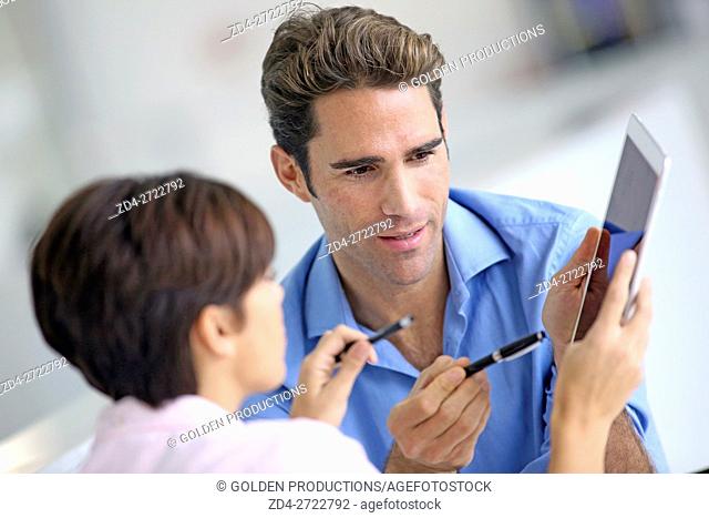 Businesspeople looking at digital tablet