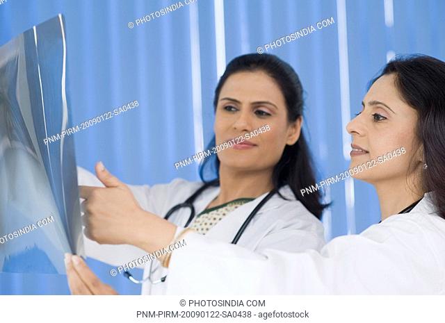 Female doctors examining an x-ray report, Gurgaon, Haryana, India