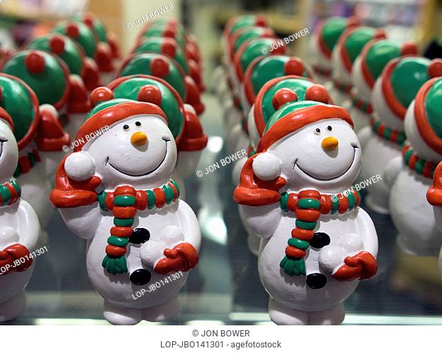 England, Oxfordshire, Oxford. Edible snowman cake and tree decorations in a shop window at Oxford covered market