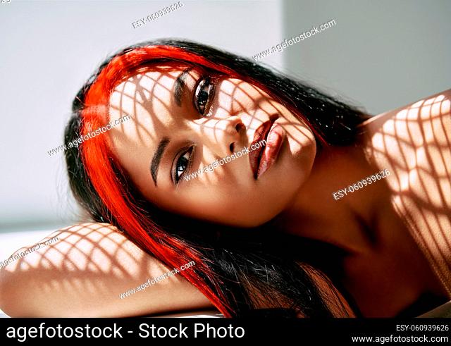 Portrait of pretty afro woman with shadows on her face. Fashion concept, female beauty
