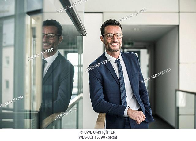 Portrait of a successful businessman, standing in office building