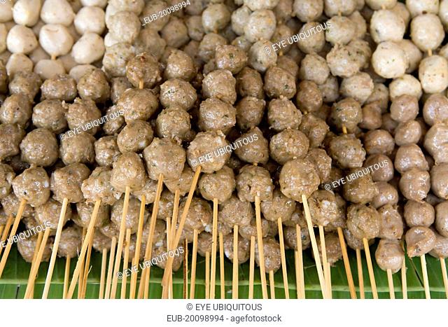 Close up of pork meat balls on wooden skewers in the market