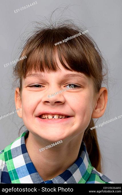 Portrait of a funny smiling ten-year-old girl of European appearance, close-up