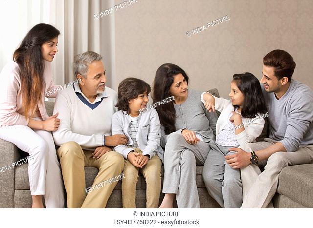 Smiling multi-generation family sitting on sofa