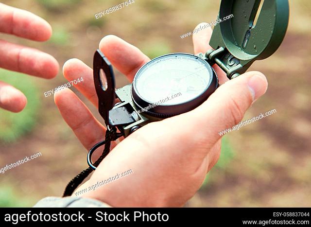 Man with compass in hand outdoor. Travel concept