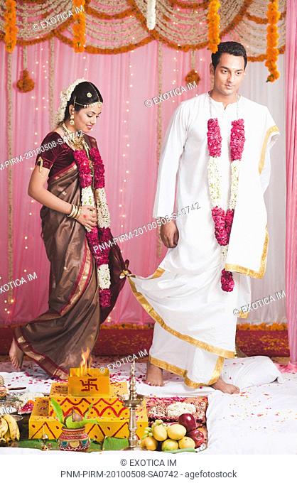 Bride and bridegroom taking Saptha Padhi during South Indian wedding