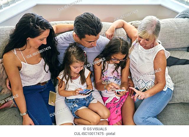 Three generation family enjoying computer games on sofa