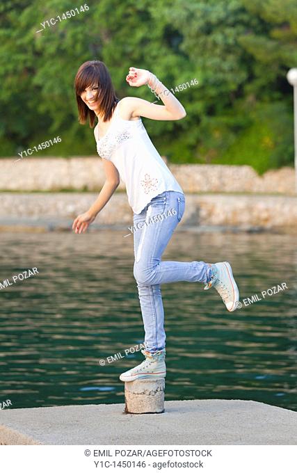 Attractive young woman is balancing on one leg