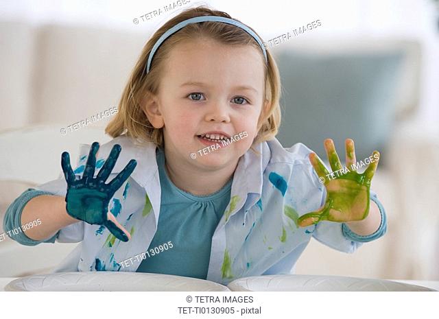 Girl finger painting with different colors