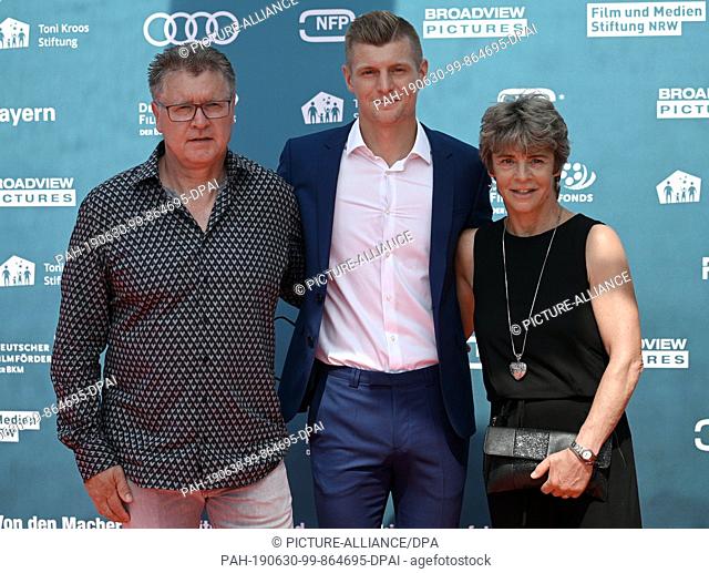 30 June 2019, North Rhine-Westphalia, Cologne: Soccer: Premiere of the documentary ""Kroos"". Footballer Toni Kroos stands on the red carpet with his parents...