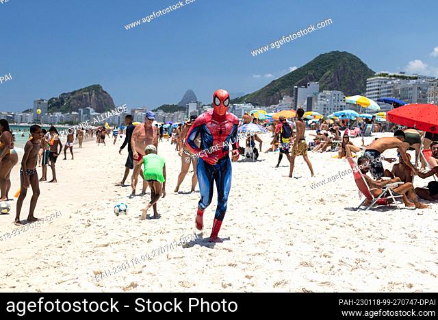 17 January 2023, Brazil, Rio de Janeiro: A man dressed as Spiderman runs on Copacabana beach in high temperatures. On Sunday