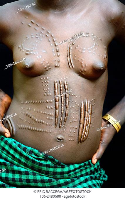 Young woman from the Bodi tribe displaying elaborate scarifications - for purely aesthetic purpose - on her body, Omo Valley, Ethiopia, Africa