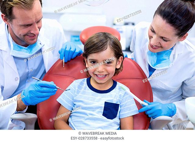 Smiling dentists examining young patient