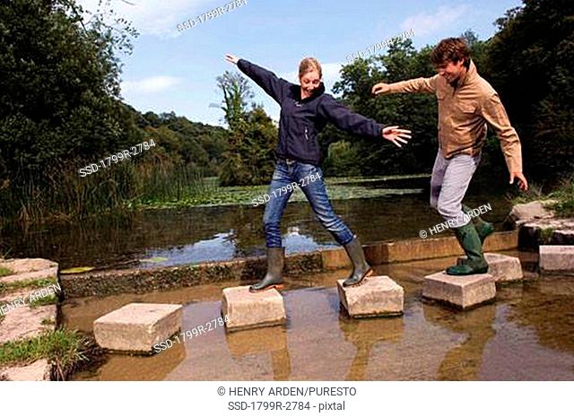 Young couple walking on stepping stones