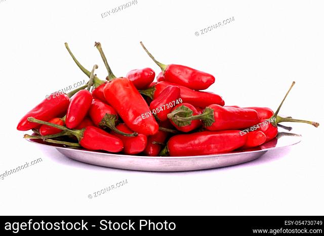 Detail view of a bunch of red chili peppers scattered isolated on a white background