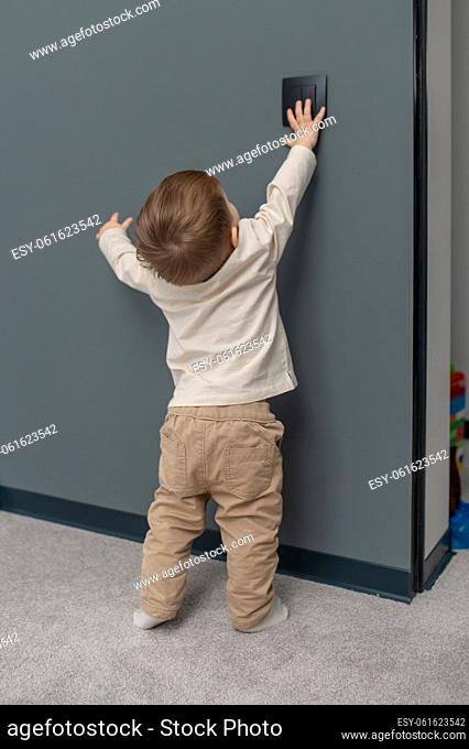 Being curious. Little baby boy trying to open the locker