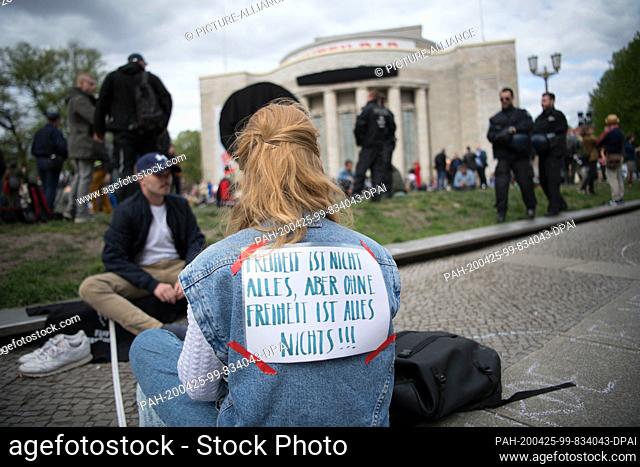 25 April 2020, Berlin: A woman carries a banner saying ""Freedom is not everything, but without freedom everything is nothing"" at a rally against the Corona...