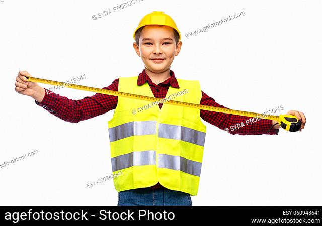 boy in construction helmet and vest with ruler