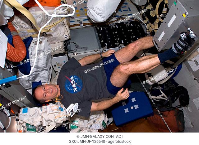 NASA astronaut Kevin Ford, STS-128 pilot, exercises on a bicycle ergometer on the middeck of Space Shuttle Discovery while docked with the International Space...
