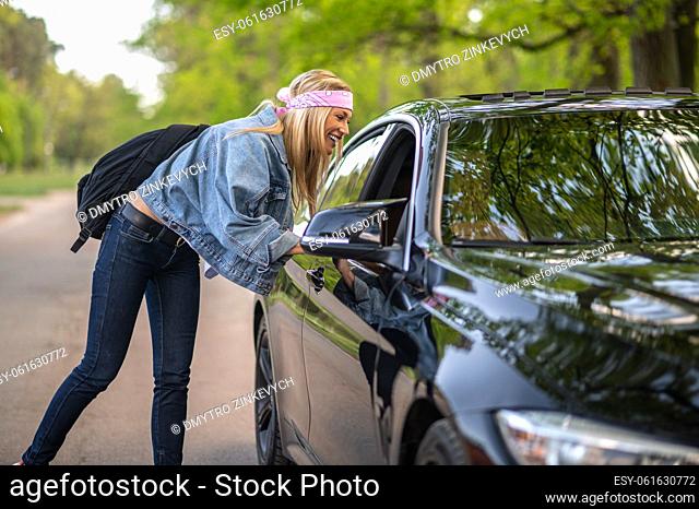 Hitchhiker. Blonde young woman stopping the care on the countryside road