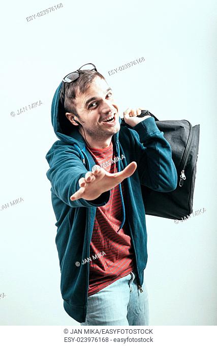 Ecstatic man in hoodie traveling with luggage