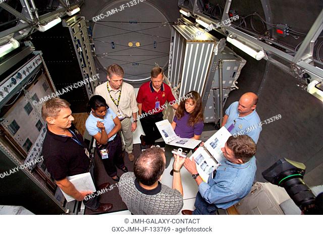 Crew trainer David Pogue (back to camera) briefs the STS-121 crew members during a training session in one of the full-scale trainers in the Space Vehicle...