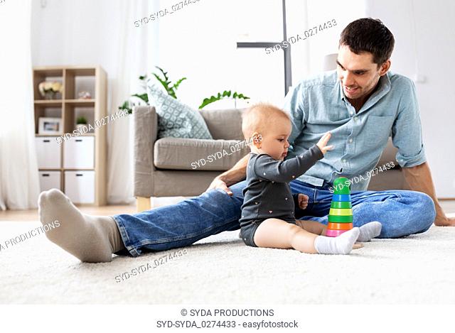 father playing with little baby daughter at home