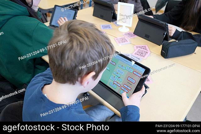 04 December 2023, Hamburg: Pupils work on a tablet during ""Fit"" learning time (individual subject training) in class 7d at Lessing-Stadtteilschule in...