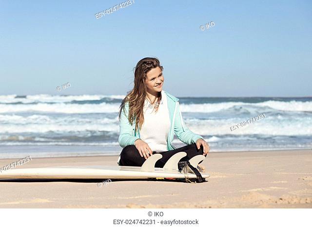Teenager girl in the beach with her surfboard