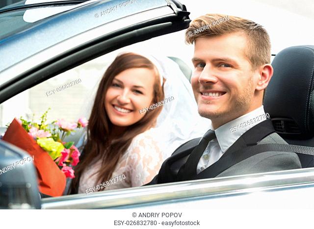Portrait Of Young Just Married Couple In The Car