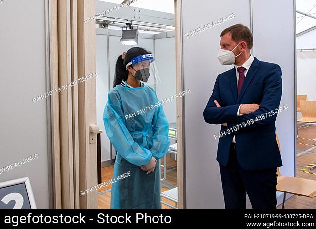 19 July 2021, Saxony, Mittweida: Michael Kretschmer (CDU), Minister President of Saxony, talks to Mai Linh Lai at the Test and Vaccination Centre at Mittweida...