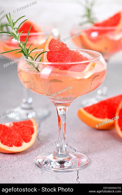 Goblet of sparkling wine with a slice of grapefruit and a sprig of rosemary