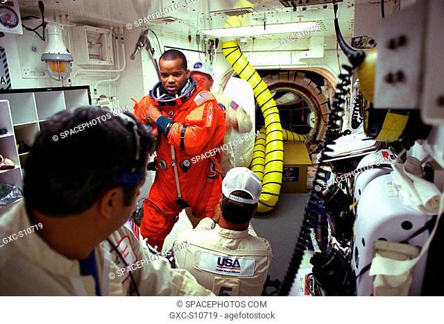 08/07/1997 --- STS-85 Mission Specialist Robert L. Curbeam, Jr. is assisted with his ascent/reentry flight suit by white room closeout crew members Mike...