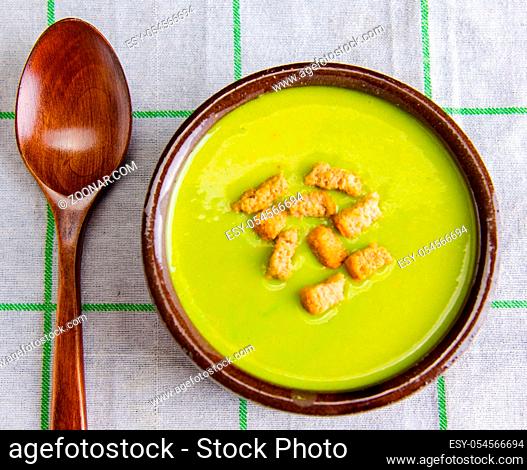 The spinach soup served on wooden board