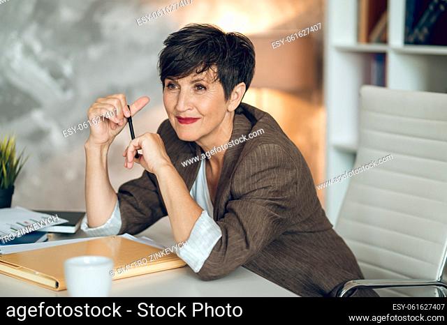 Good-looking businesswoman. Pretty mature woman smiling nicely and looking positive