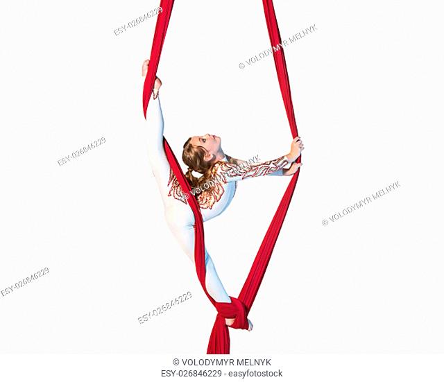 Graceful gymnast performing aerial exercise with red fabrics on white background