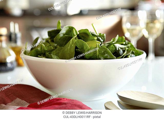 Bowl of spinach salad on kitchen table