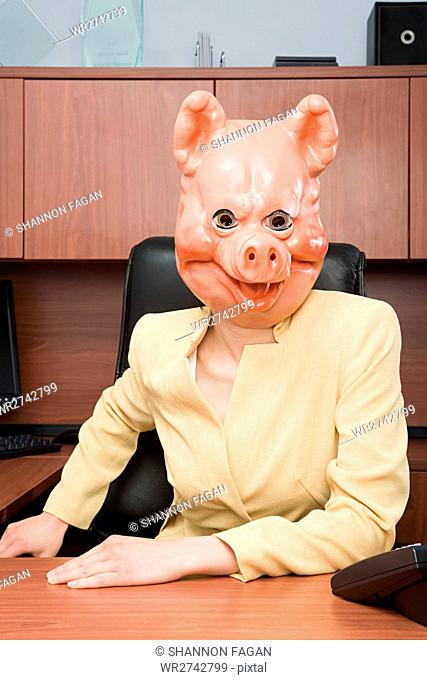 Portrait of businesswoman in a pig mask