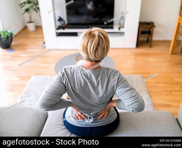 Elderly woman at home with lower back pain
