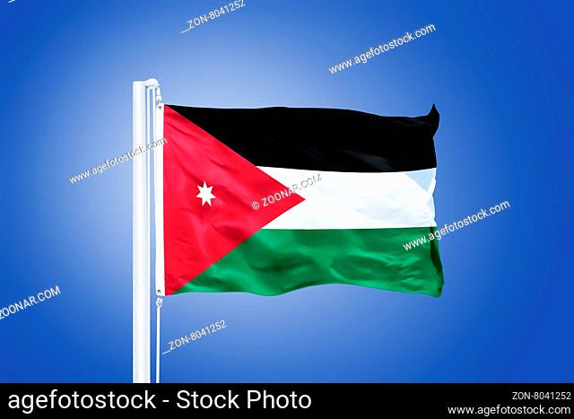 Flag of Jordan flying against a blue sky