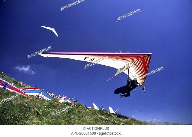 Hang glider taking off from a busy hill side